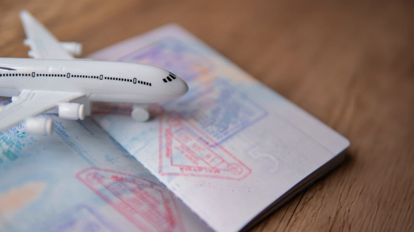 Passport with Thai entry stamps and a toy plane on a table