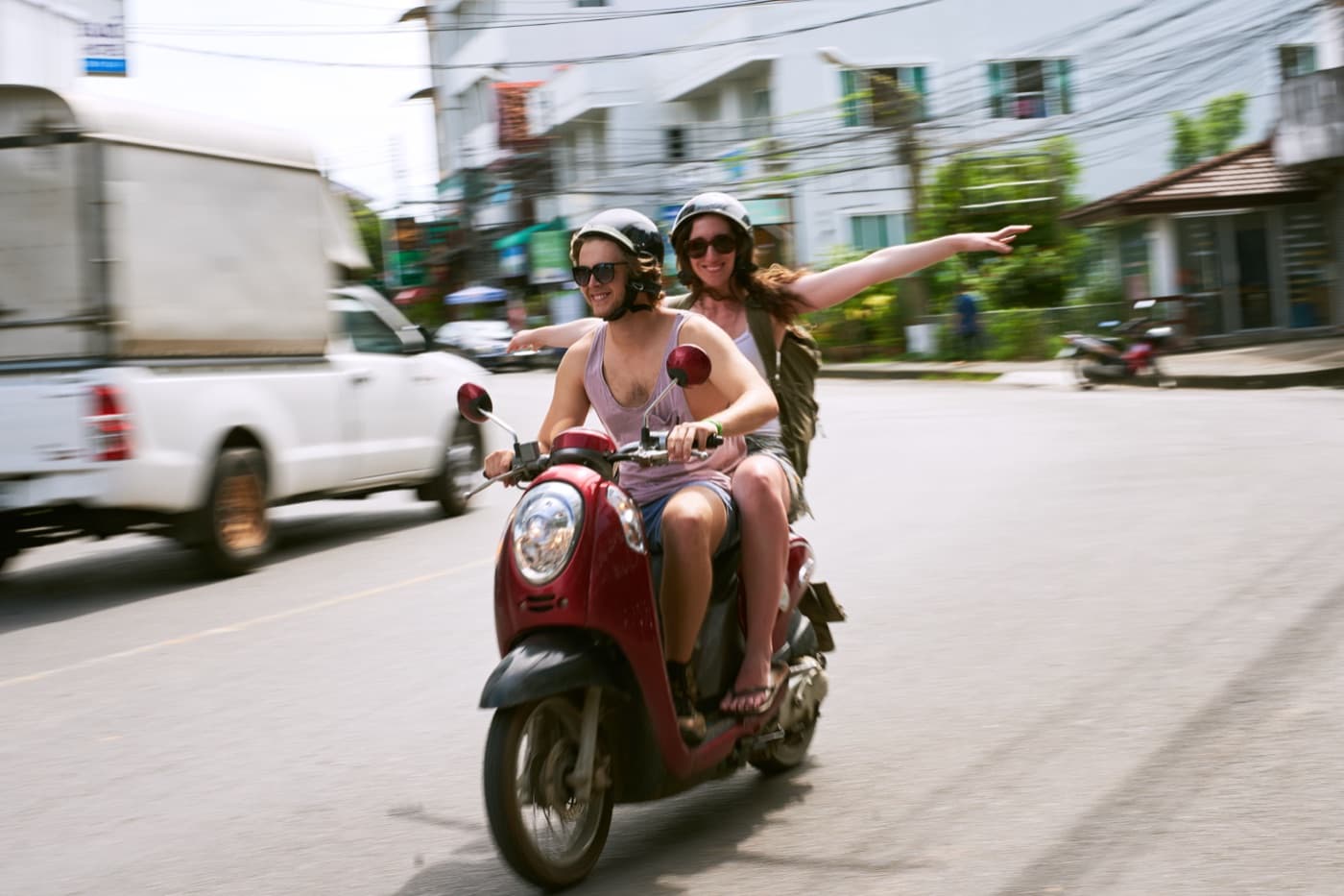 Two visitors on a rented scooter on a Thai street